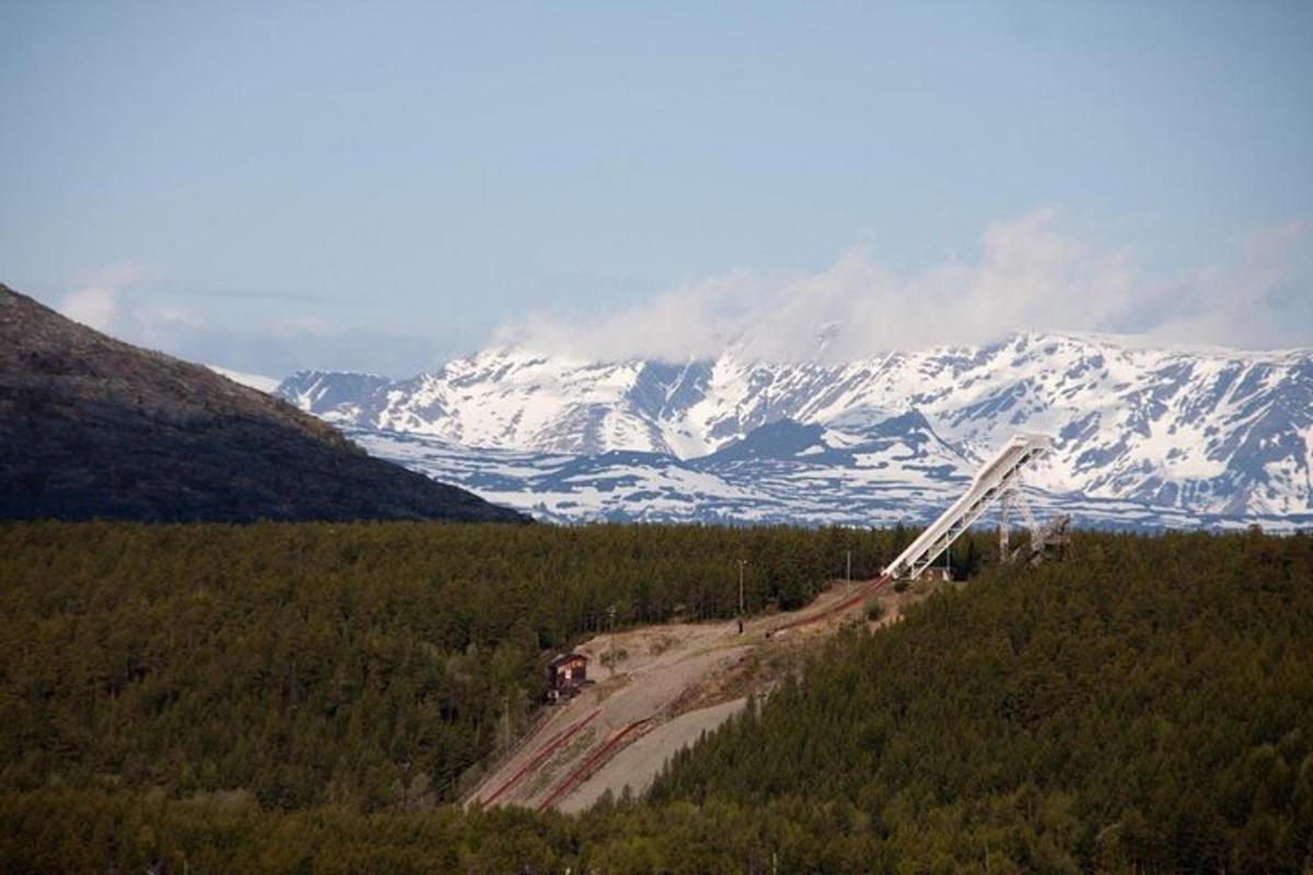 a dirt road in front of a snow covered mountain