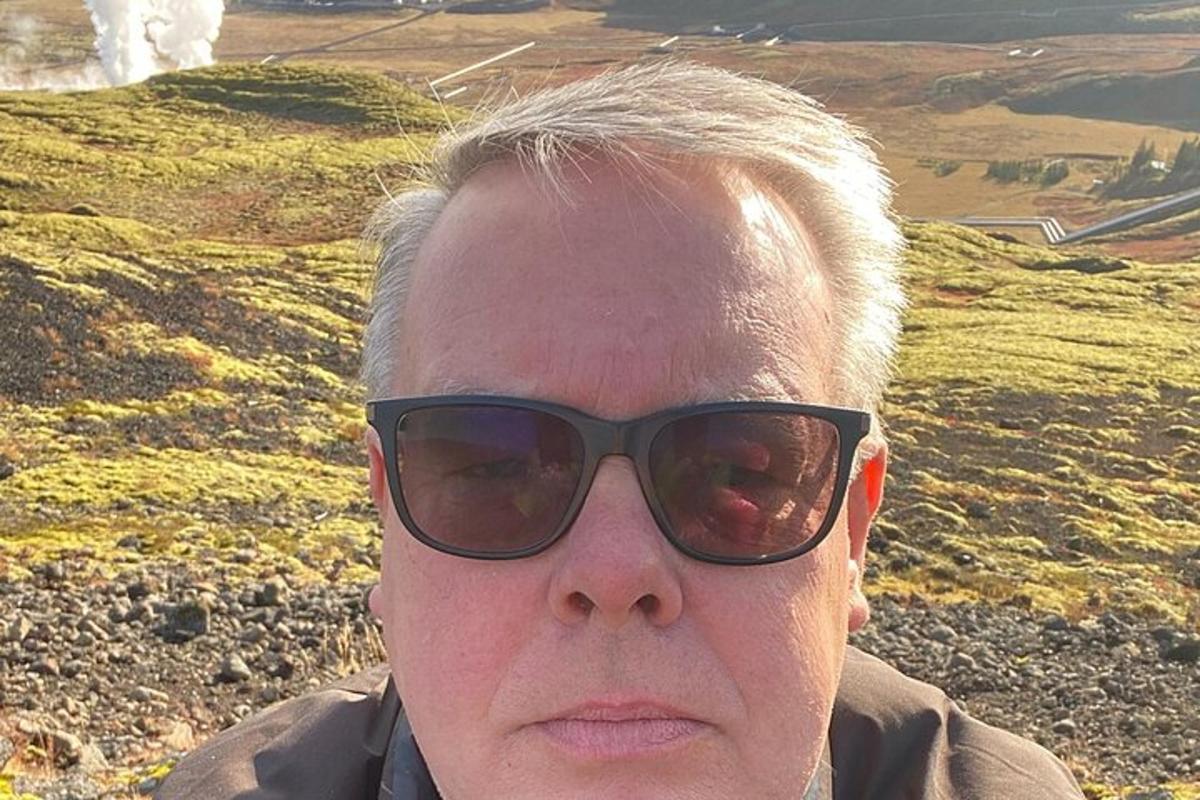en kvinne med solbriller på toppen av en ås