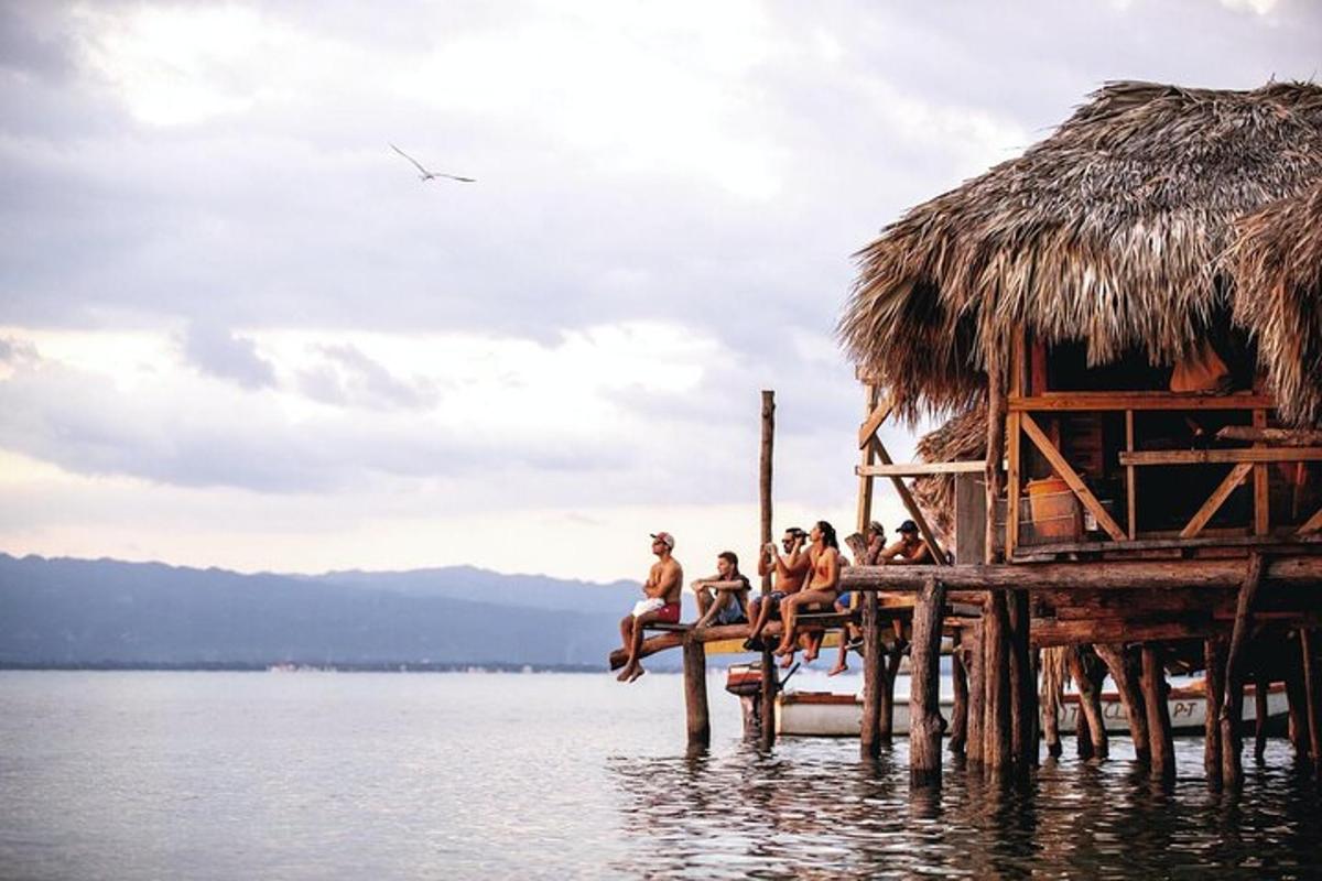a group of people sitting on a dock in the water