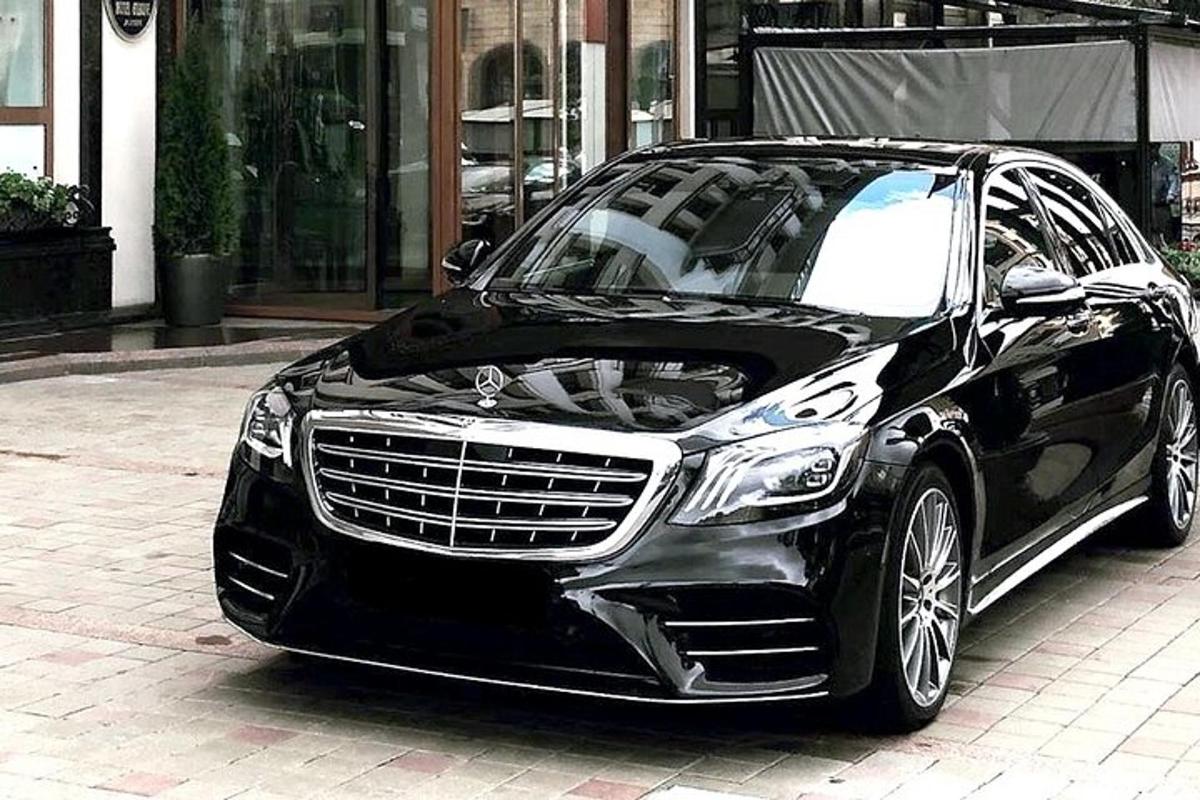 một chiếc xe màu đen đỗ trên một con phố lát gạch