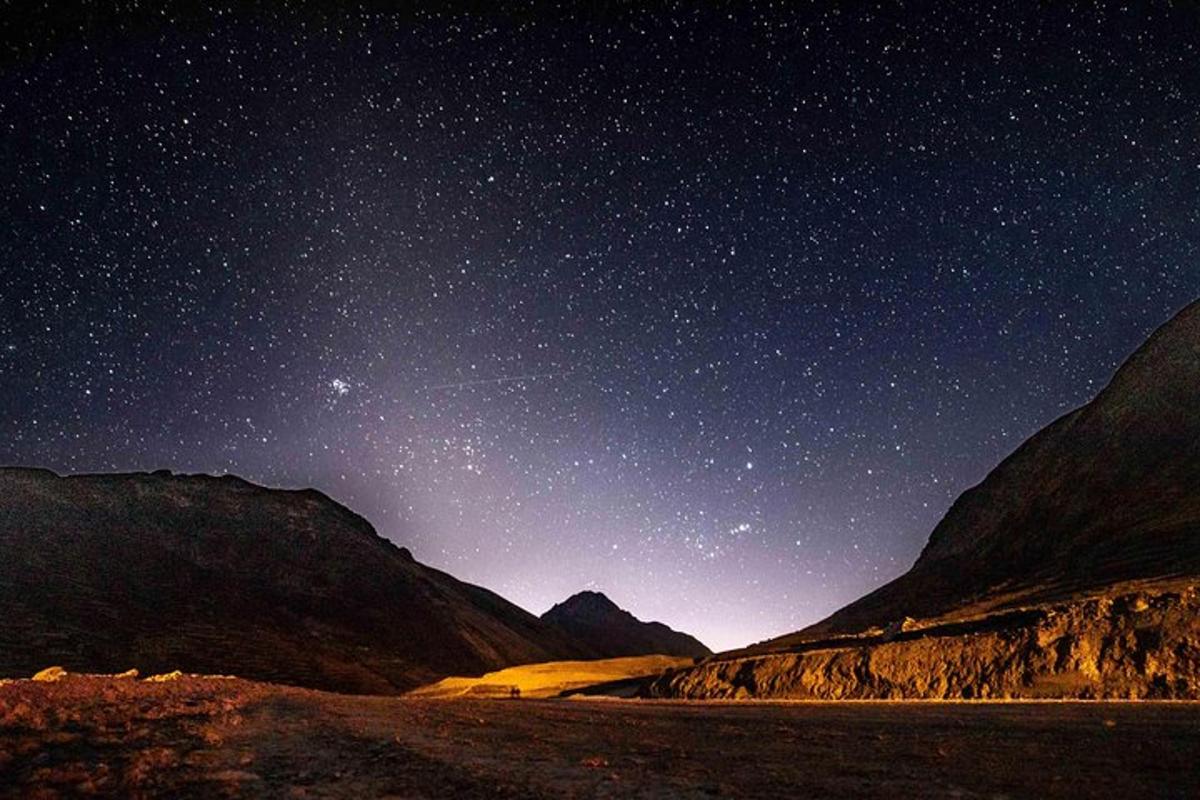 um céu noturno cheio de estrelas e uma estrada de terra