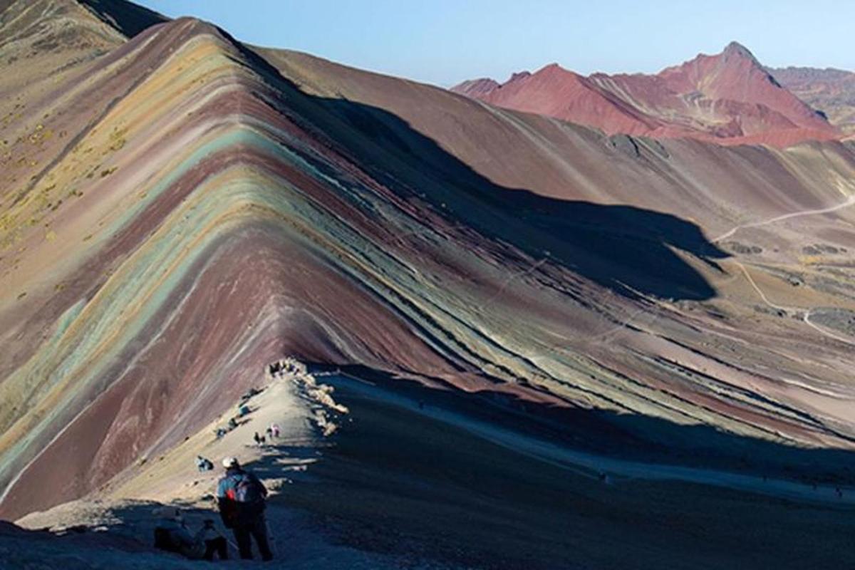 um homem parado na encosta de uma montanha