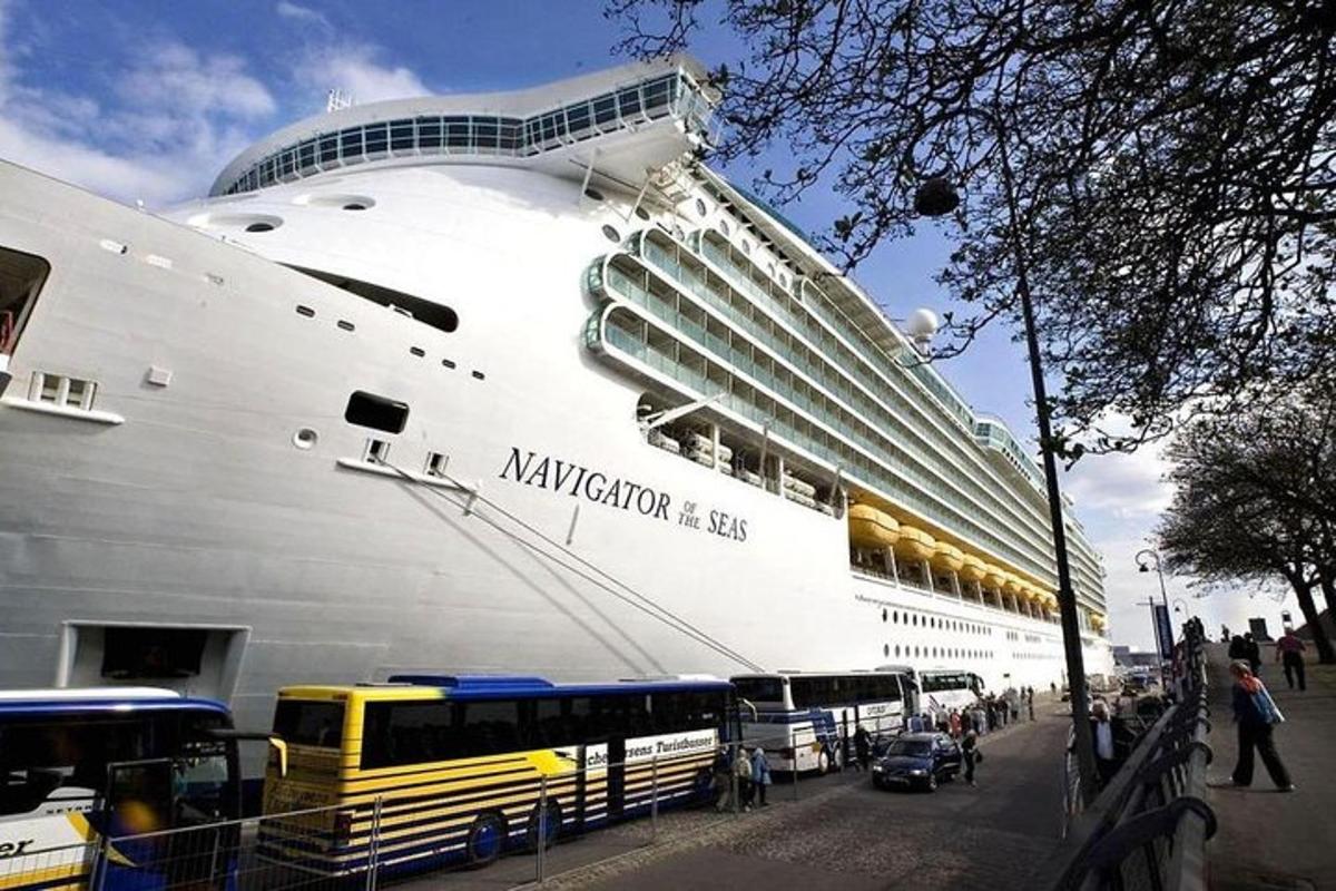 a large cruise ship is docked next to a bus