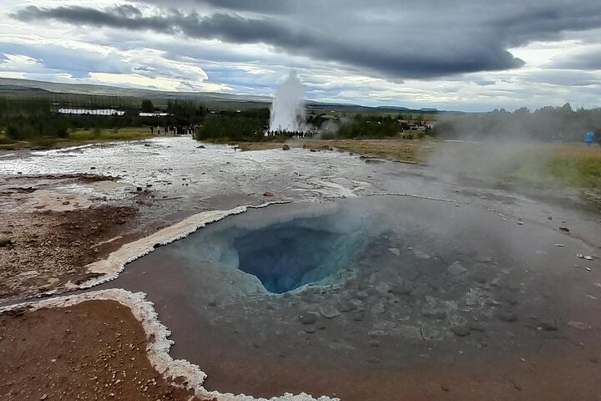a large pool of water and steam in a field