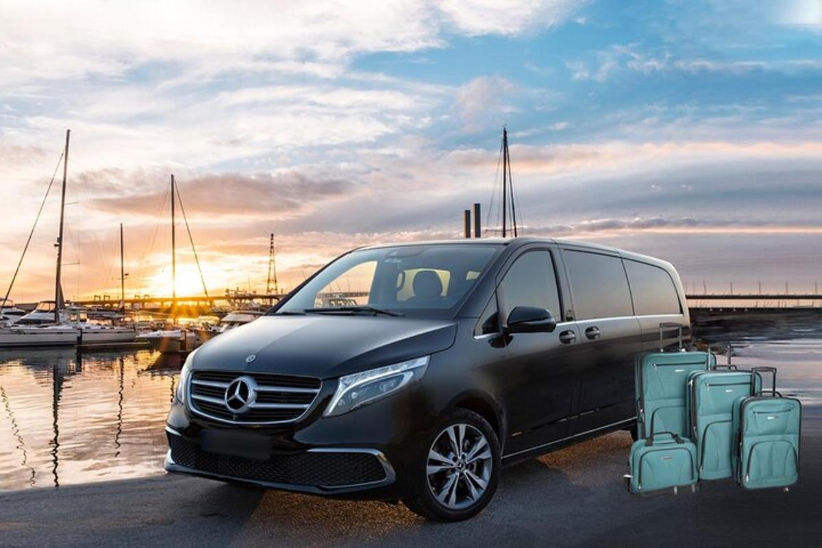 a black mercedes benz van parked next to a marina
