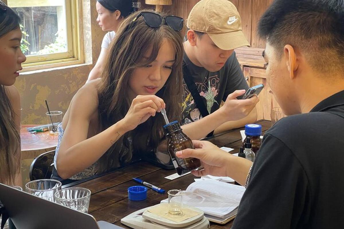 a group of people sitting at a table looking at their cell phones