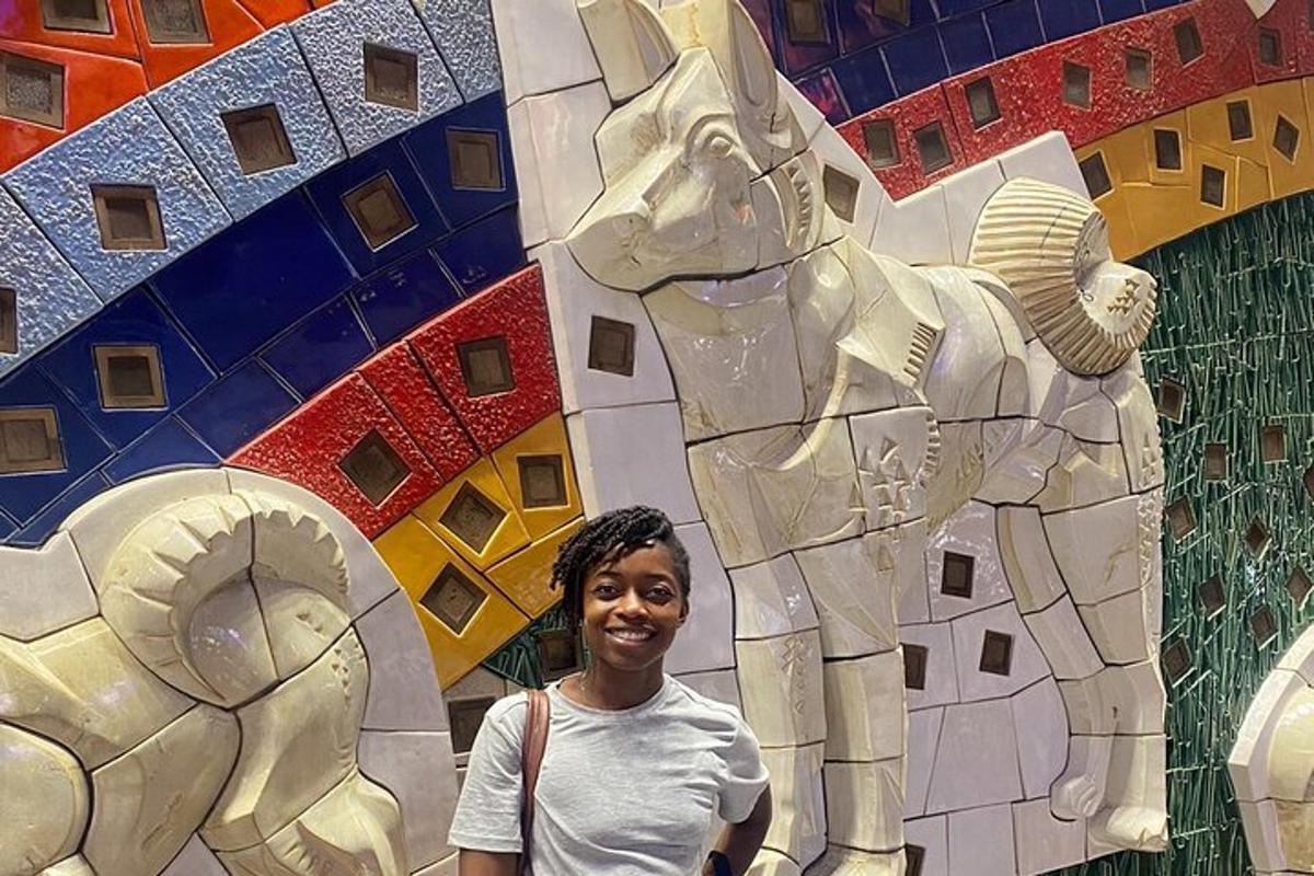 a woman standing in front of a wall with an elephant
