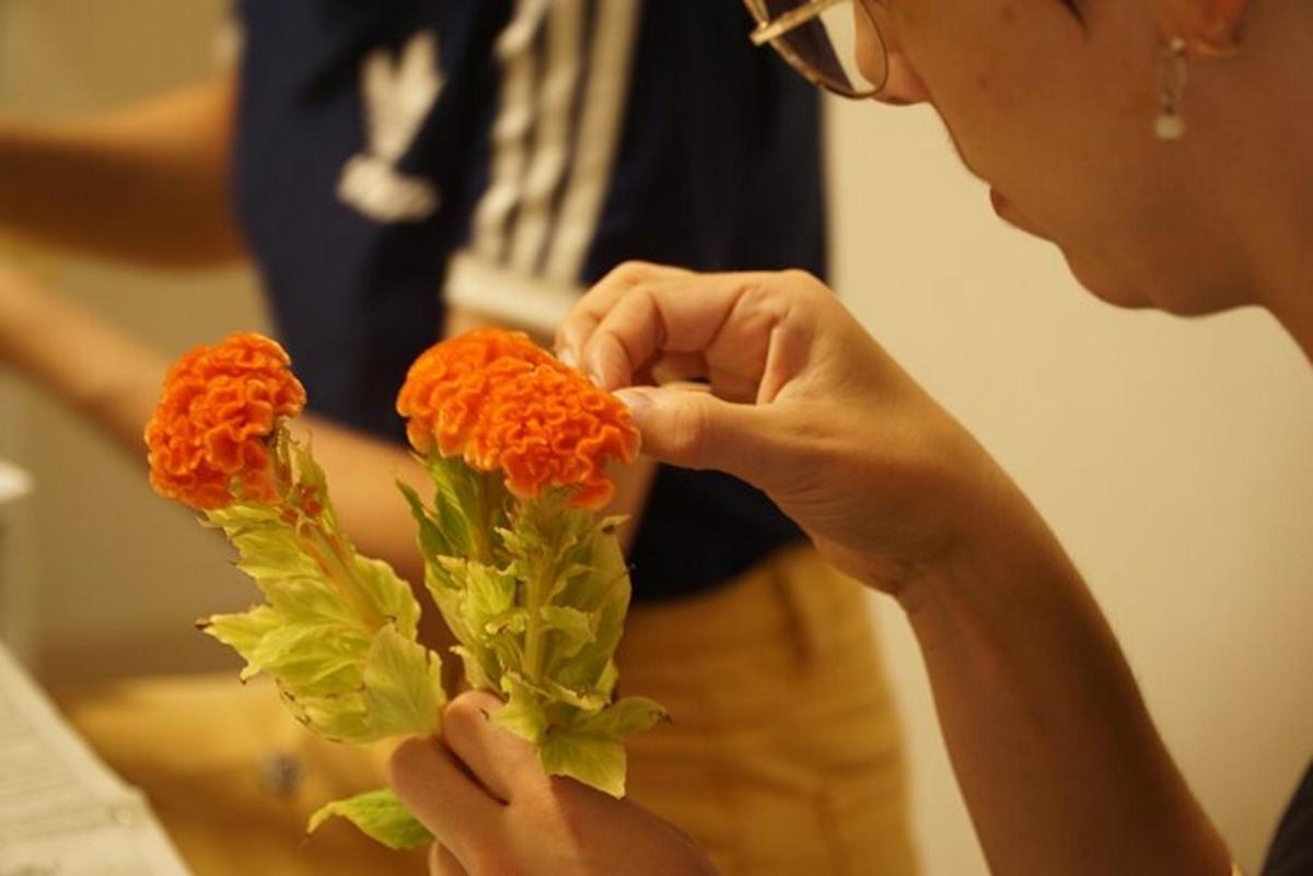 en kvinne holder en bukett med oransje blomster