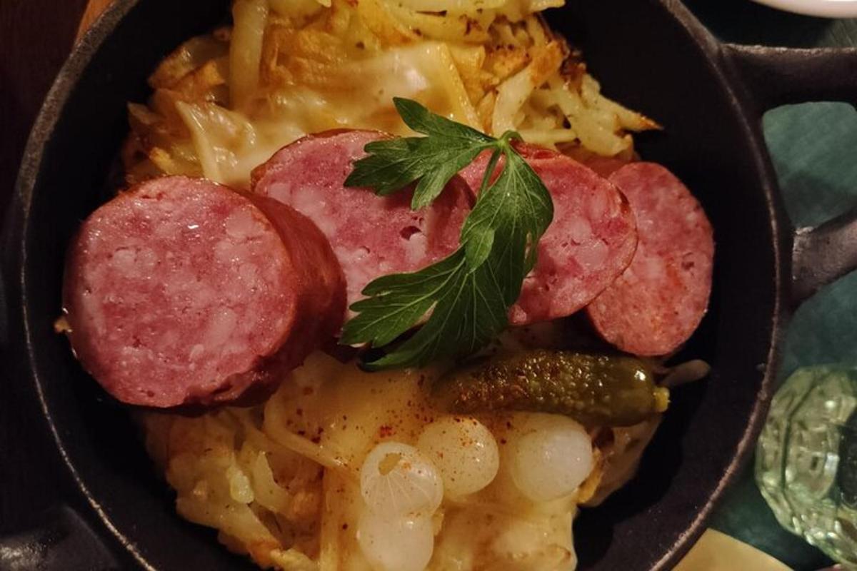 Svartur skál af mat með pylsum og pasta