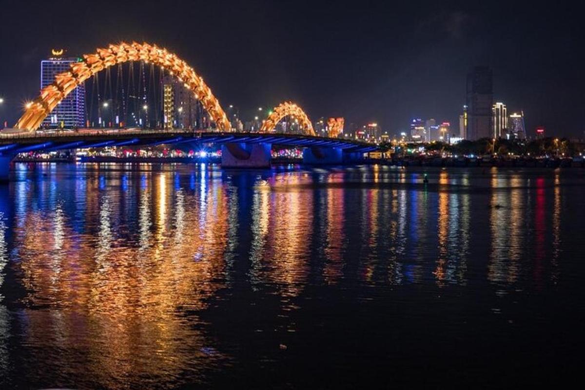 uma ponte sobre a água com uma cidade à noite