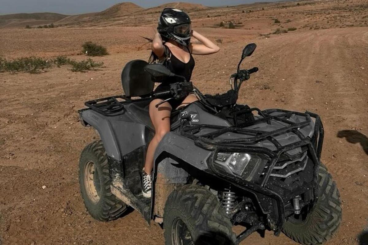 a woman sitting on a atv in the desert