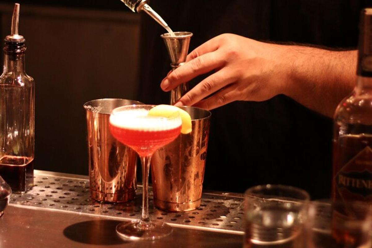 uma pessoa despeja uma bebida em uma taça de martini