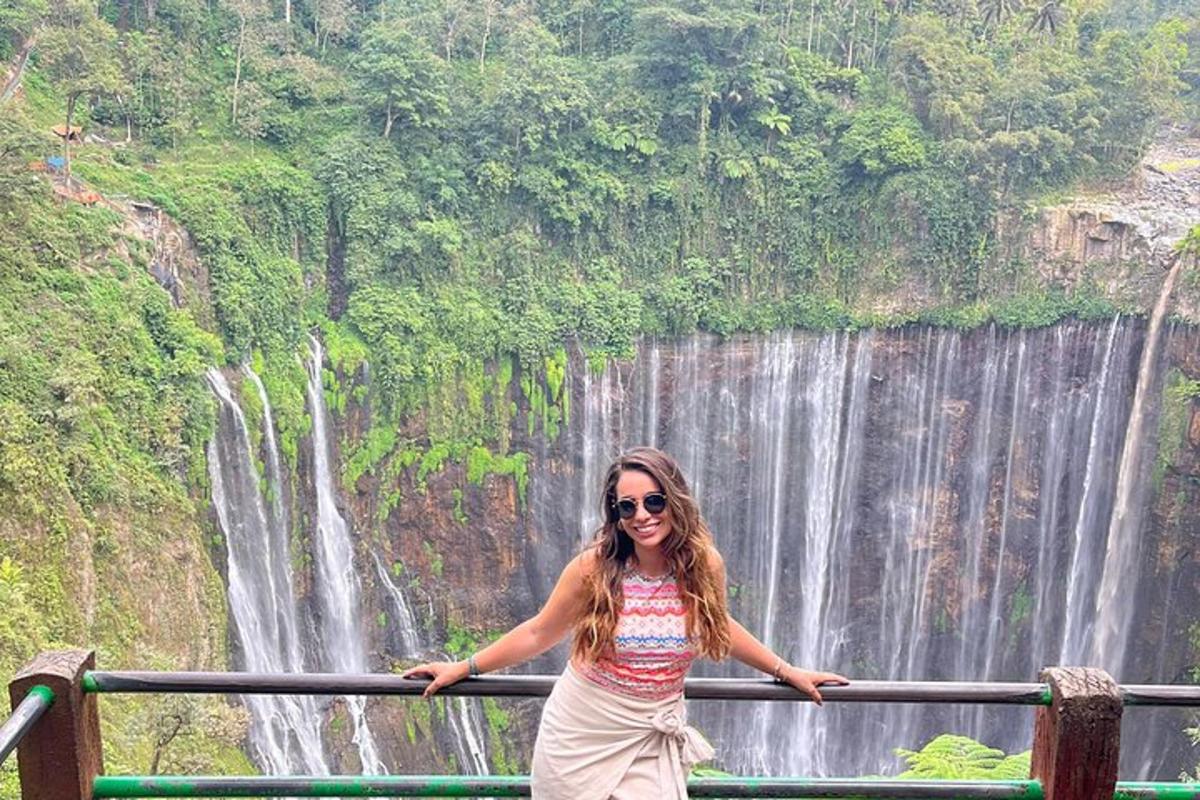 a woman standing in front of a waterfall
