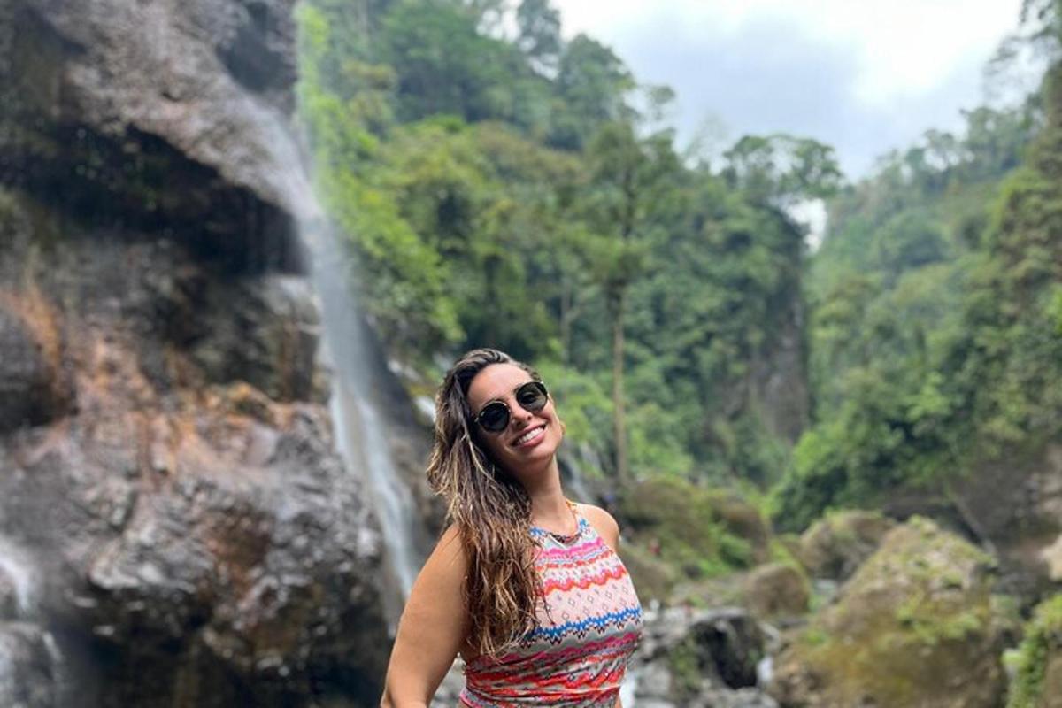 a woman standing in front of a waterfall