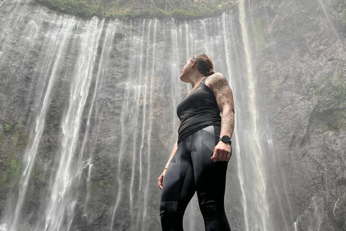 a woman standing in front of a waterfall