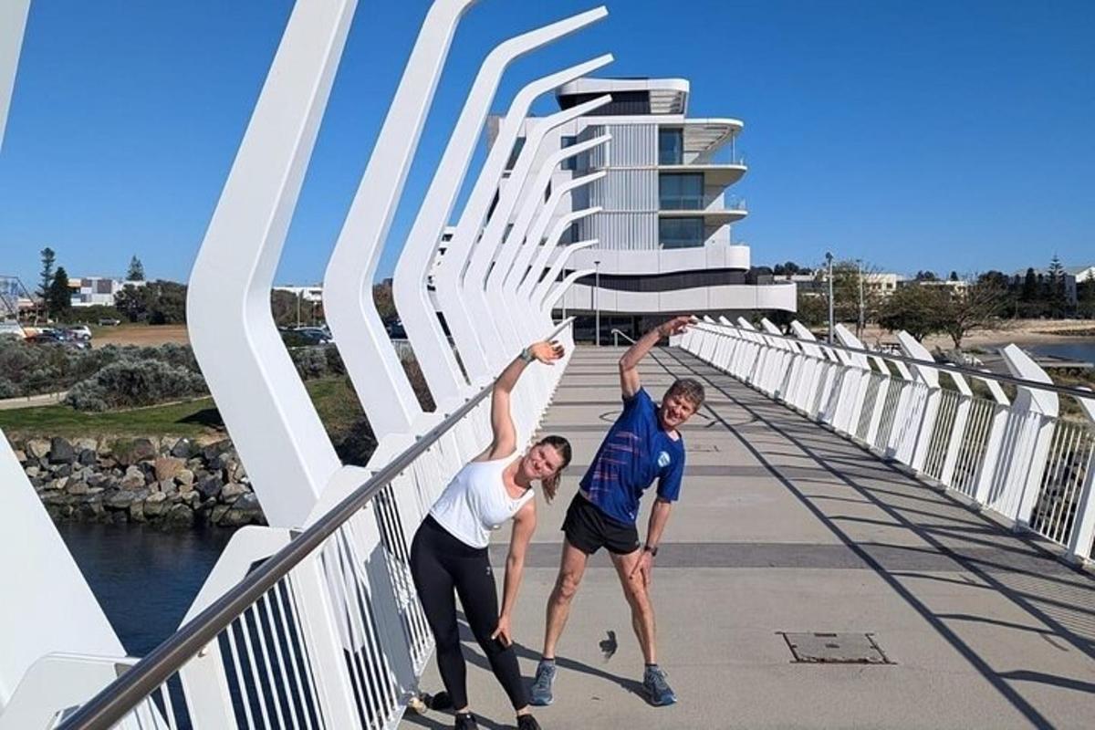 a man and a woman jumping in the air on a bridge