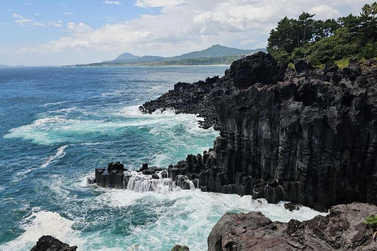 pemandangan lautan dengan air terjun di pantai berbatu