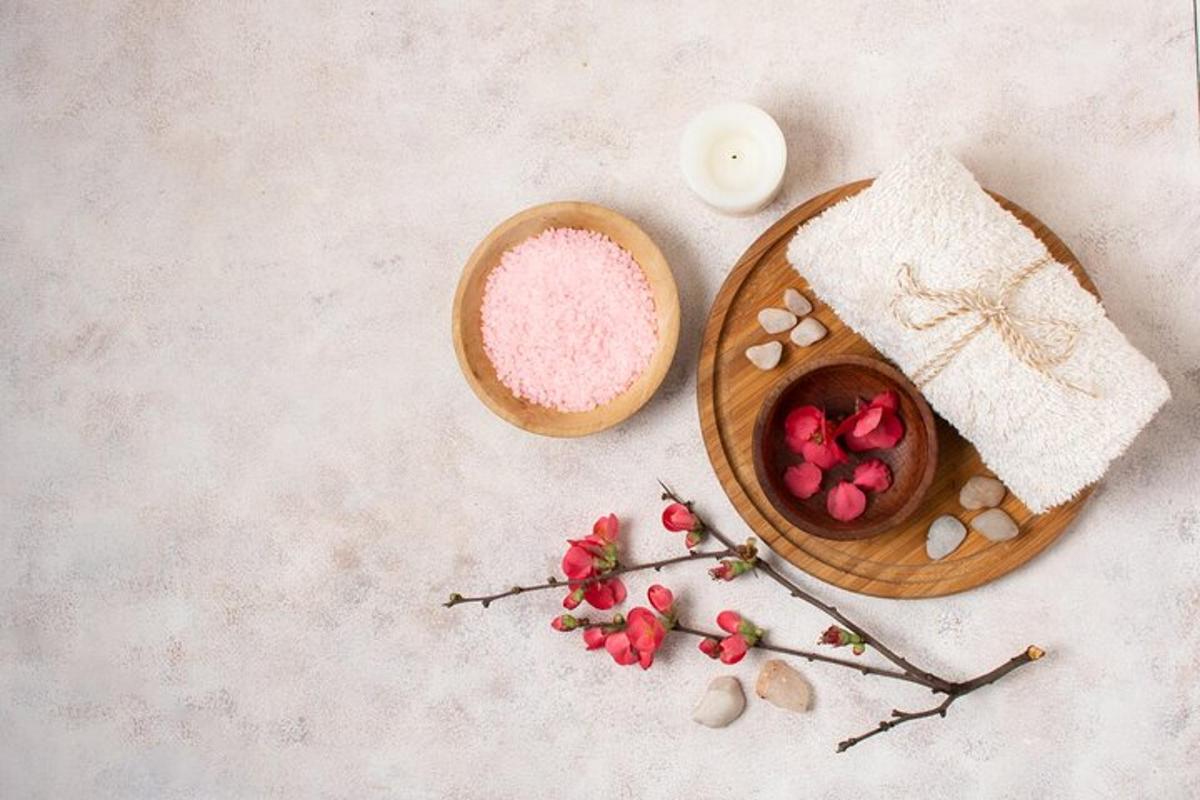 uma mesa com uma tigela de pó rosa e uma tigela de flores