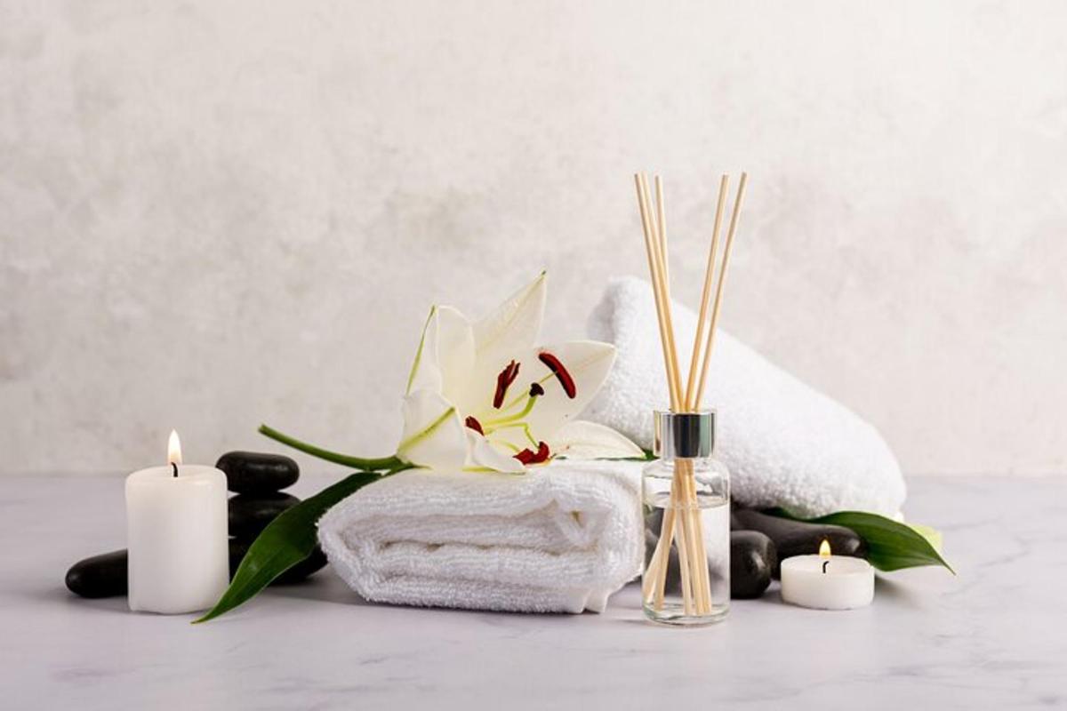 un bagno con candele, asciugamani e un fiore