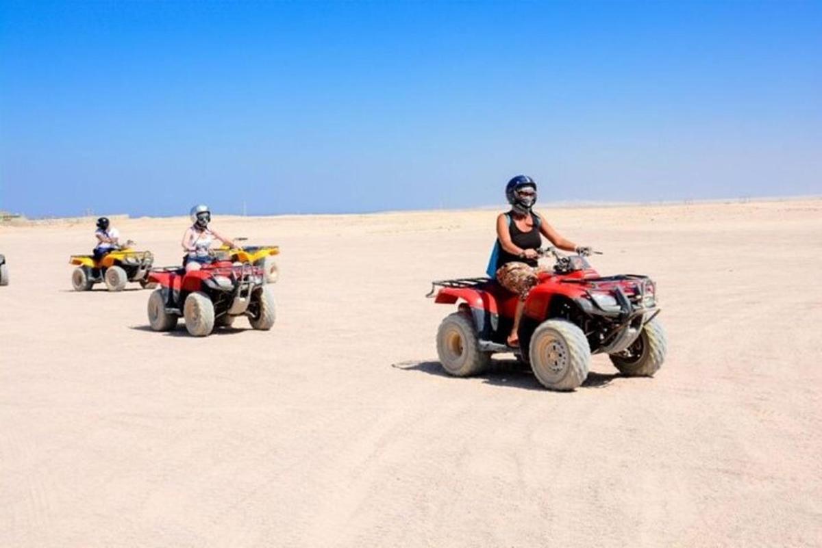 Un grupo de personas conduciendo vehículos todo terreno en el desierto.