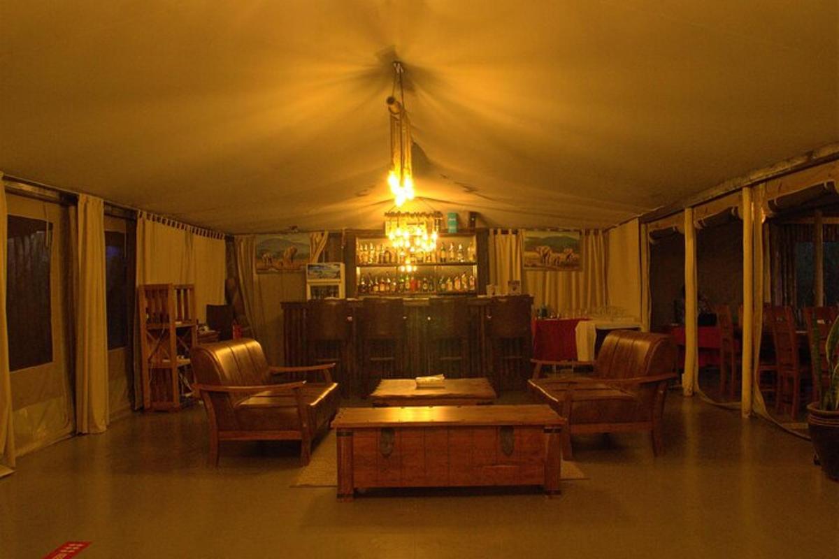 uma sala de estar com mesa e cadeiras em uma tenda