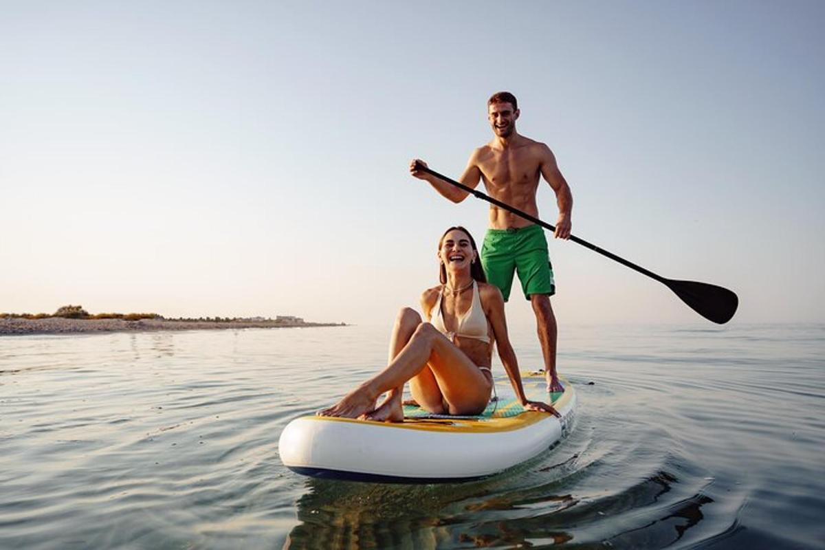 een man en een vrouw op een paddleboard in het water