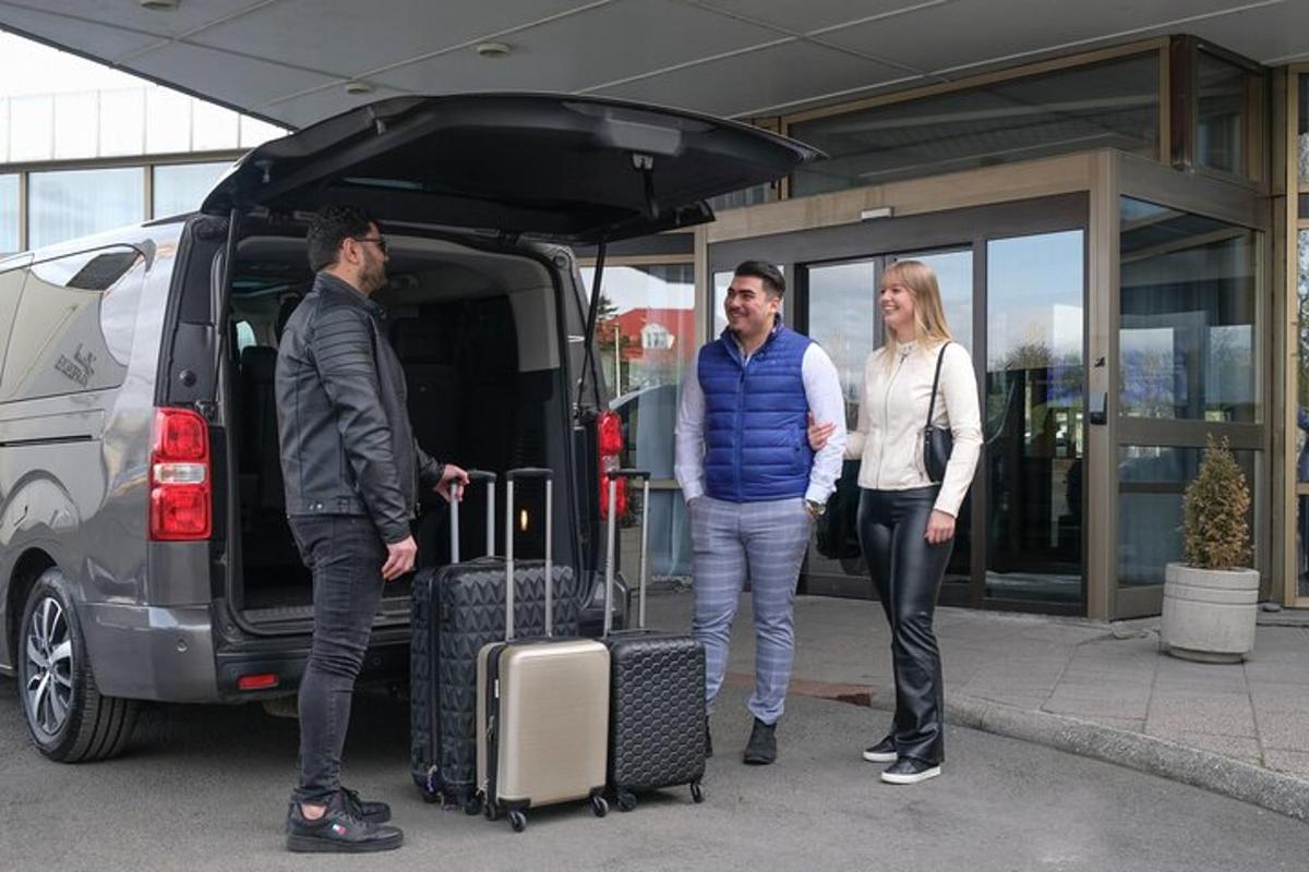 kolm inimest seisavad kaubiku tagaosas oma pagasiga
