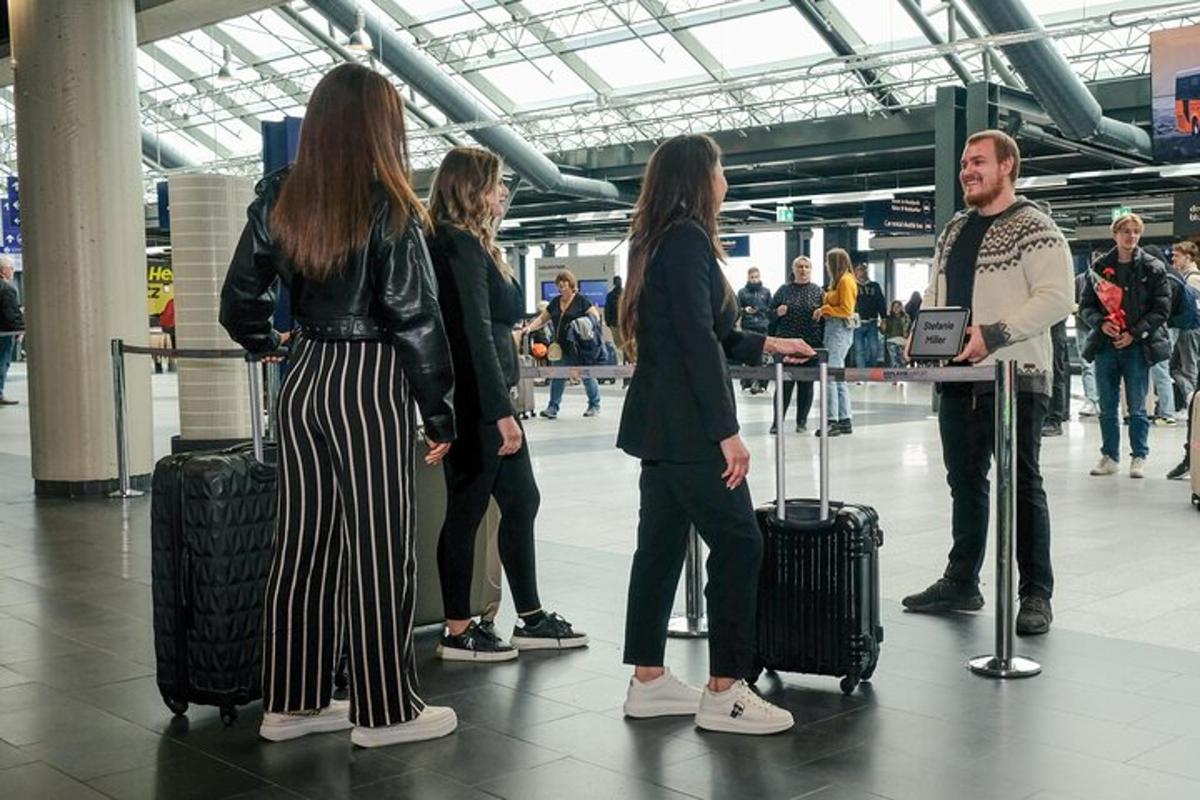 Un grupo de personas de pie en un aeropuerto con equipaje.
