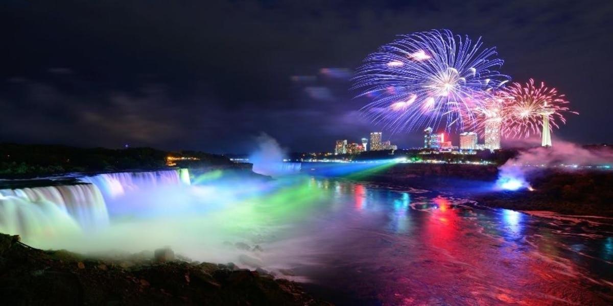 a firework display over a niagara falls at night