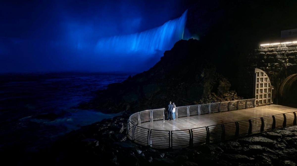a man standing on a bridge at night