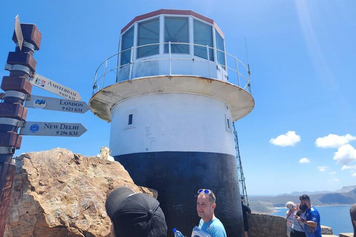 a group of people standing around a lighthouse
