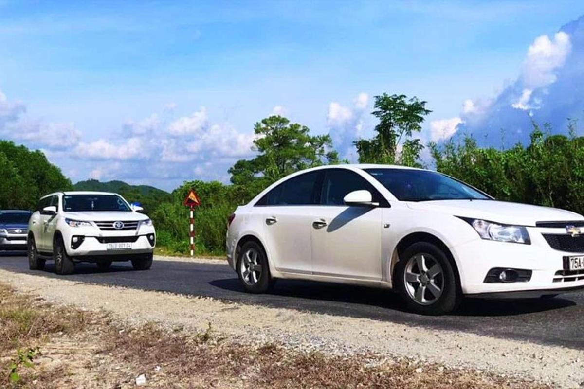 Dos coches blancos estacionados al costado de una carretera