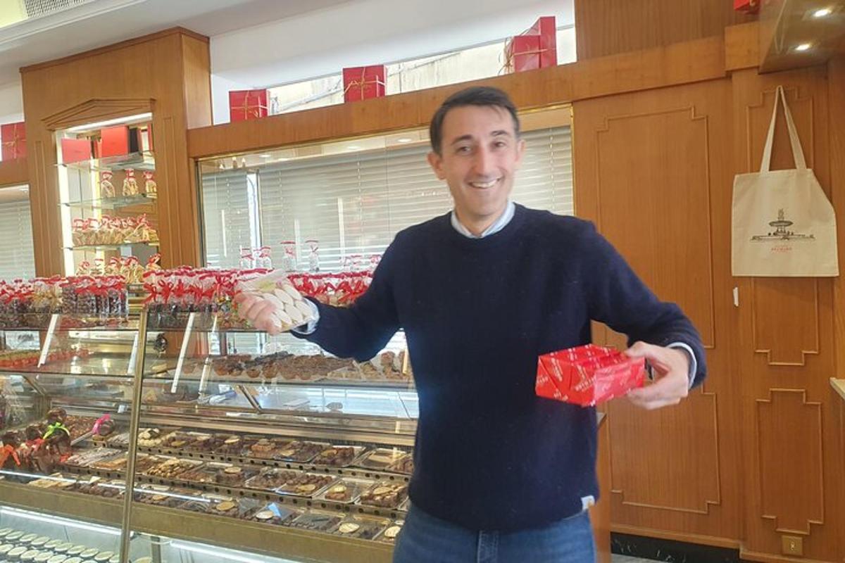 a man is holding a box of donuts in a store