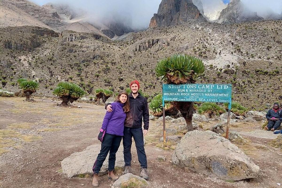 un uomo e una donna in piedi accanto a un cartello