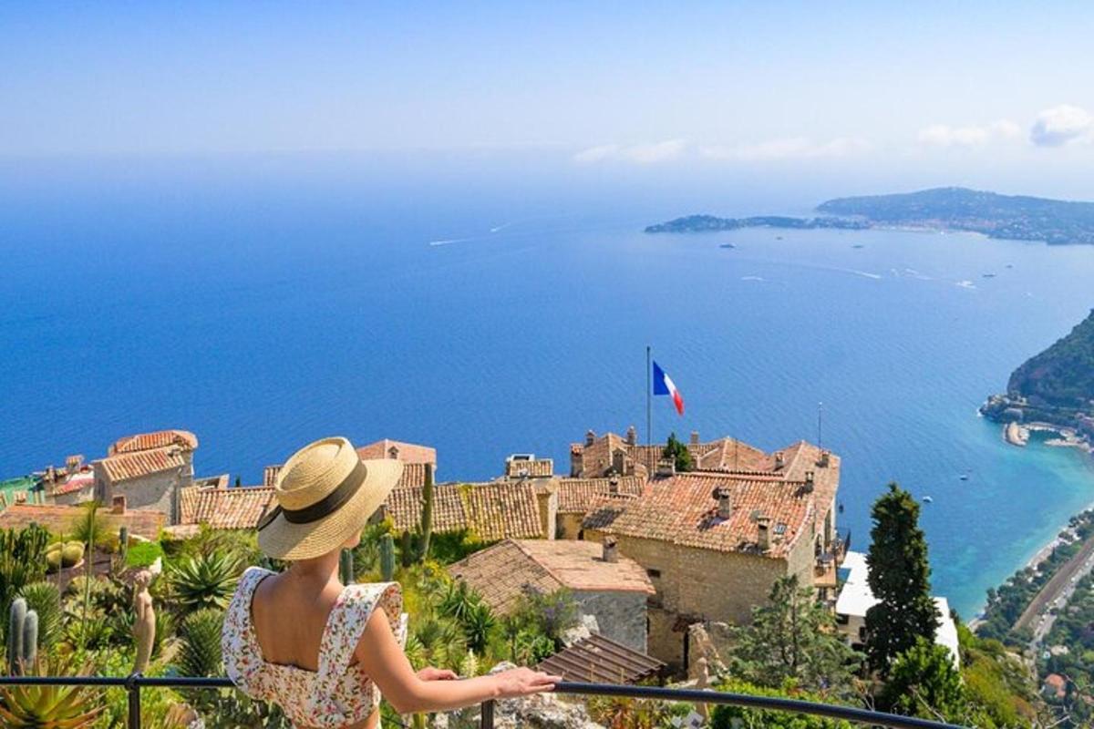 una donna con un cappello in piedi su un balcone che guarda un castello