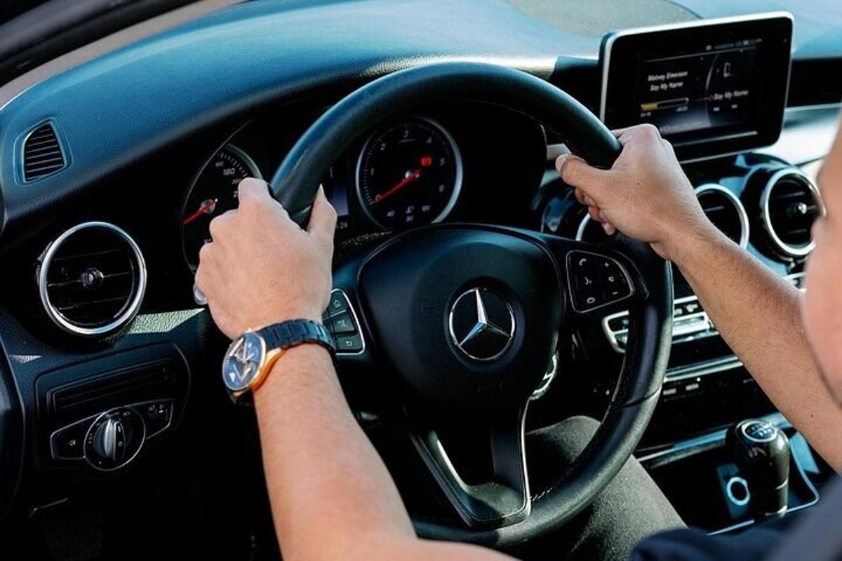 a person driving a car with their hands on the steering wheel