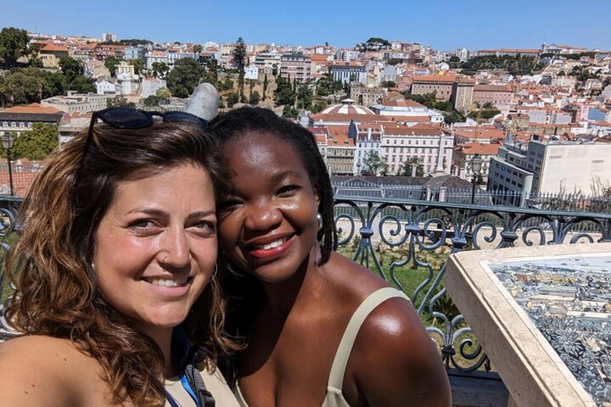 two women posing for a picture with a view of a city