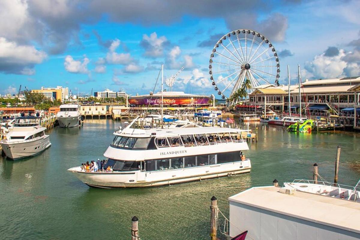 a large white boat in a harbor with a ferris wheel