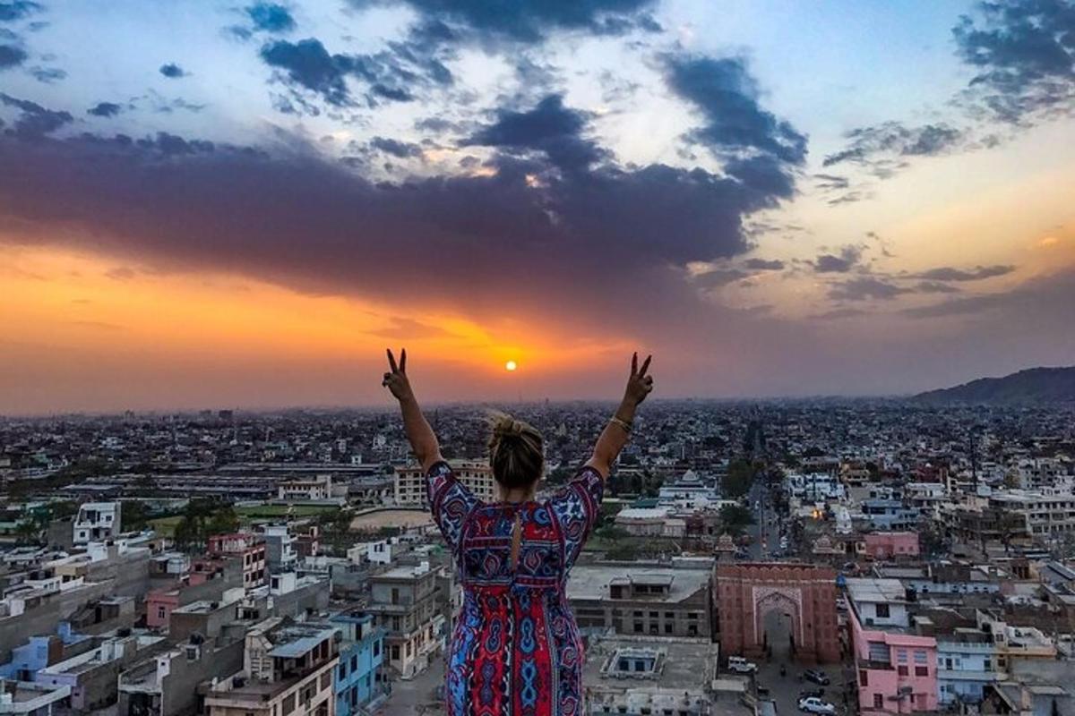 a woman standing on top of a city with her arms up