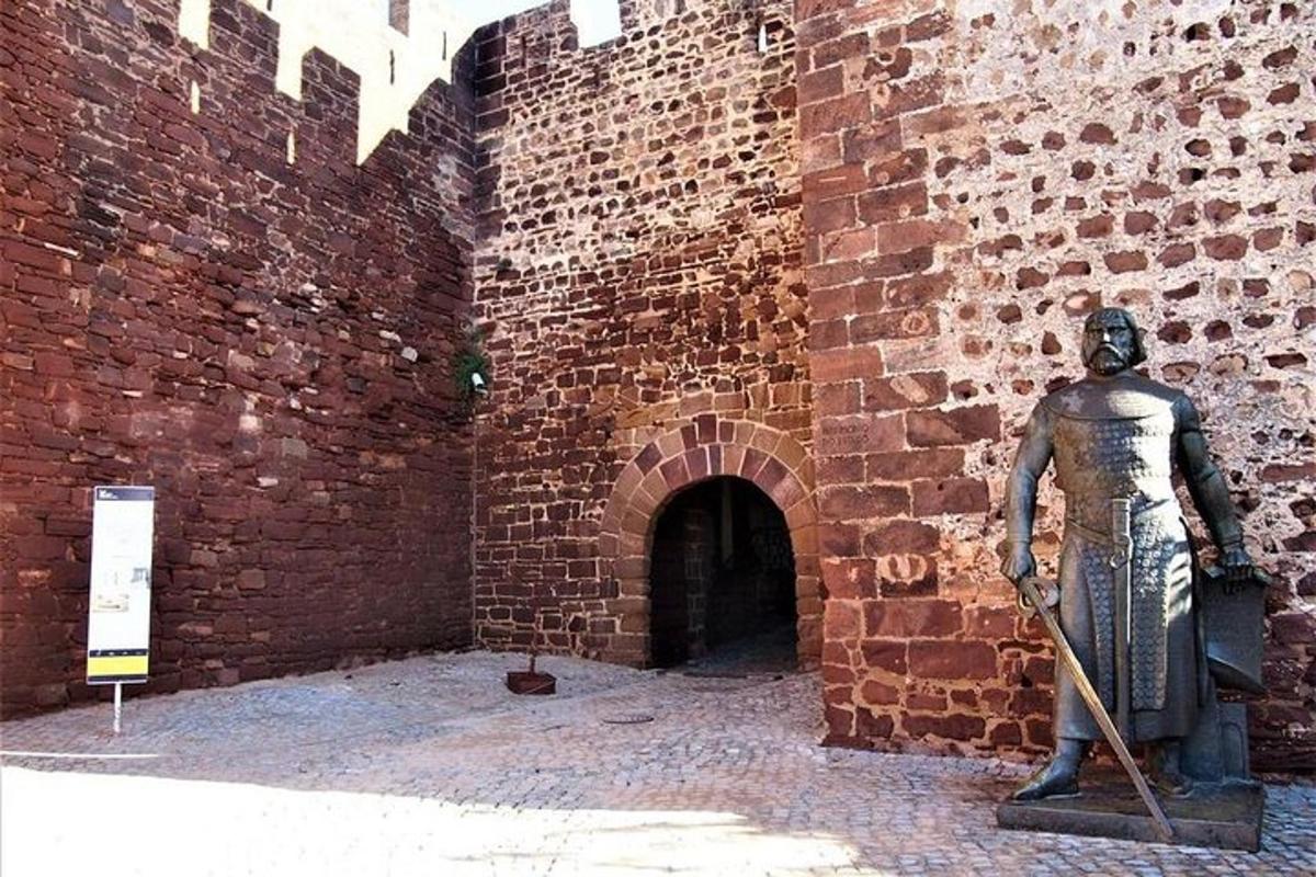 socha muža stojaceho vedľa tehlovej steny