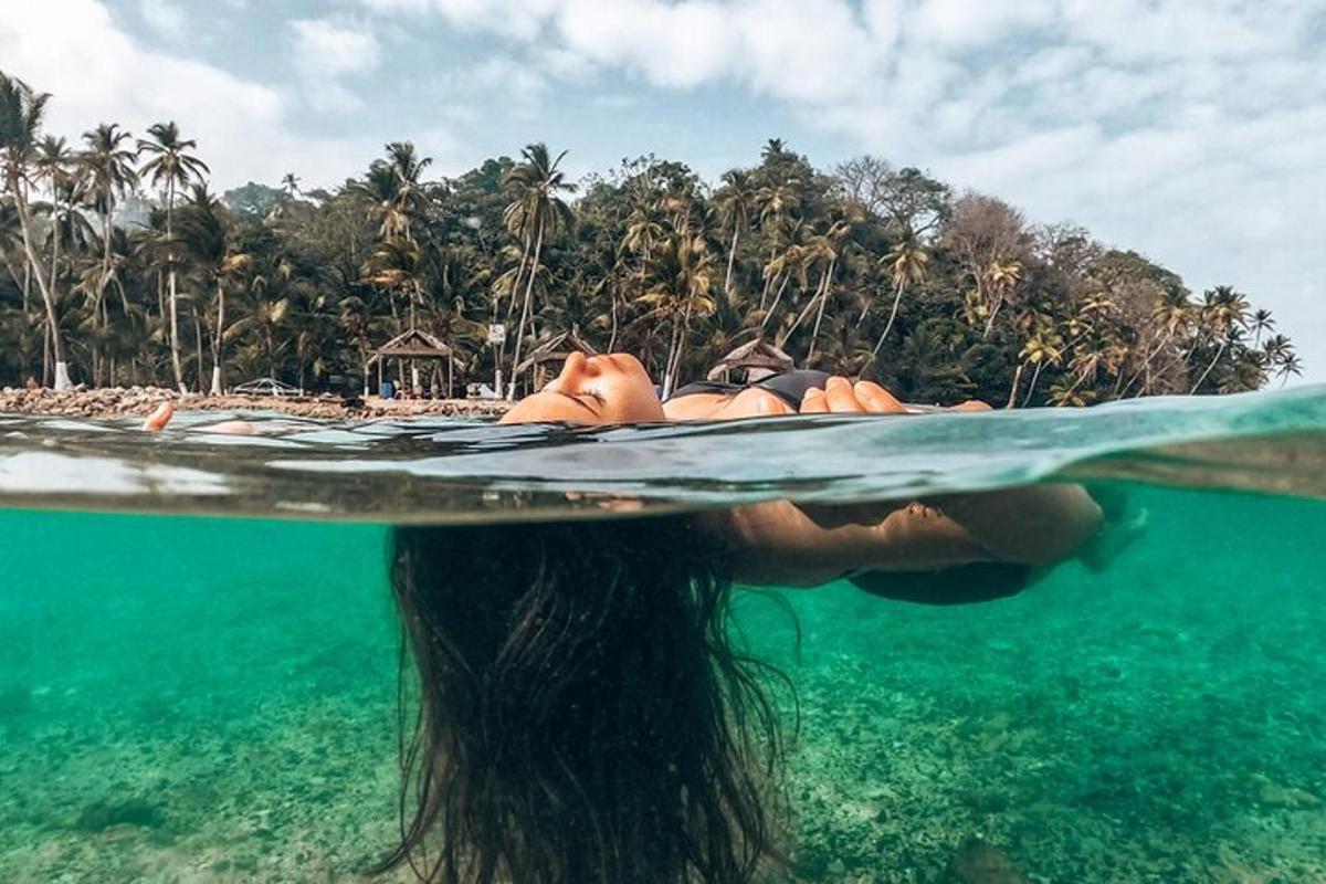 žena leži na dasci za surfanje u oceanu