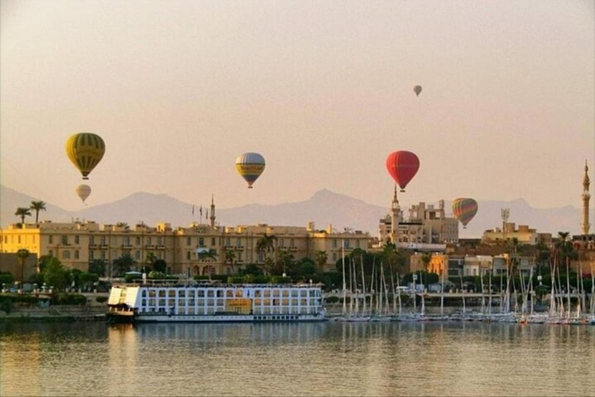 egy csoport hőlégballon repül a víz felett