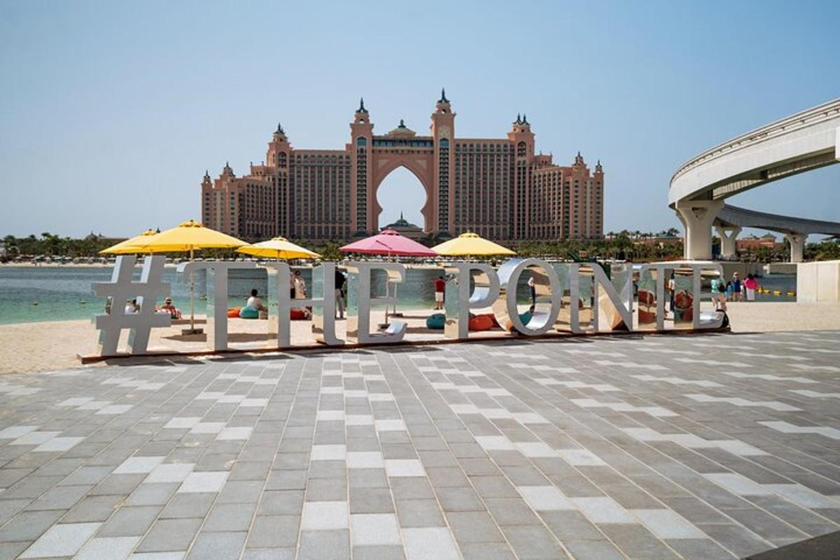 egy üdülőhely napernyőkkel ellátott stranddal és a szálloda szóval