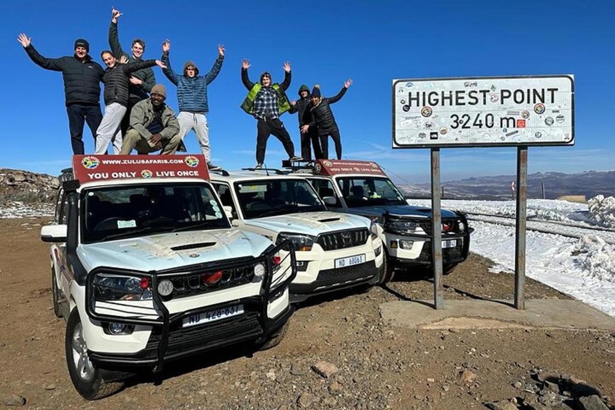 un gruppo di persone in piedi sopra le loro auto
