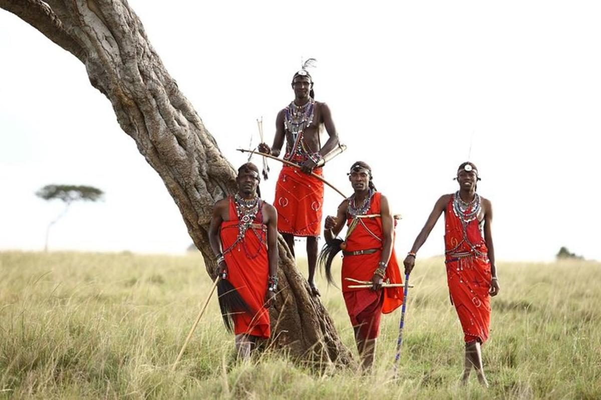 a group of men standing next to a tree