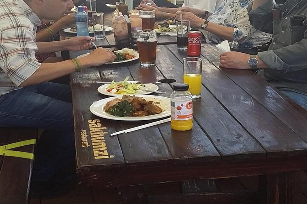 un grup de persones assegudes a una taula de fusta amb plats de menjar