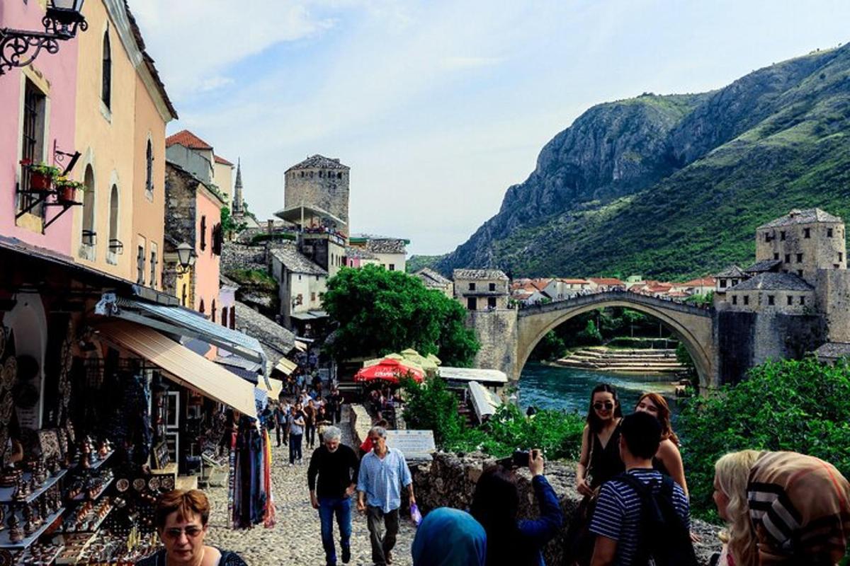 um grupo de pessoas caminhando por uma rua com uma ponte