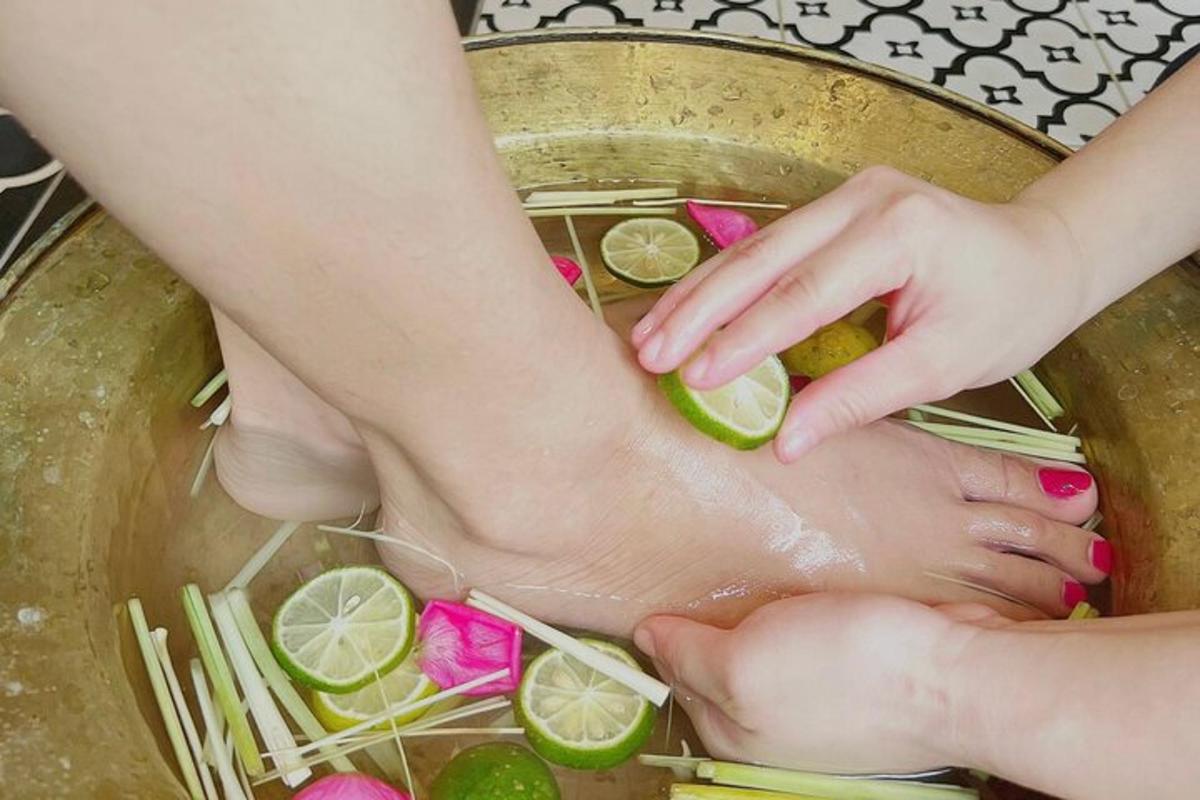 seorang wanita merendam kakinya di dalam kolam air dengan kapur