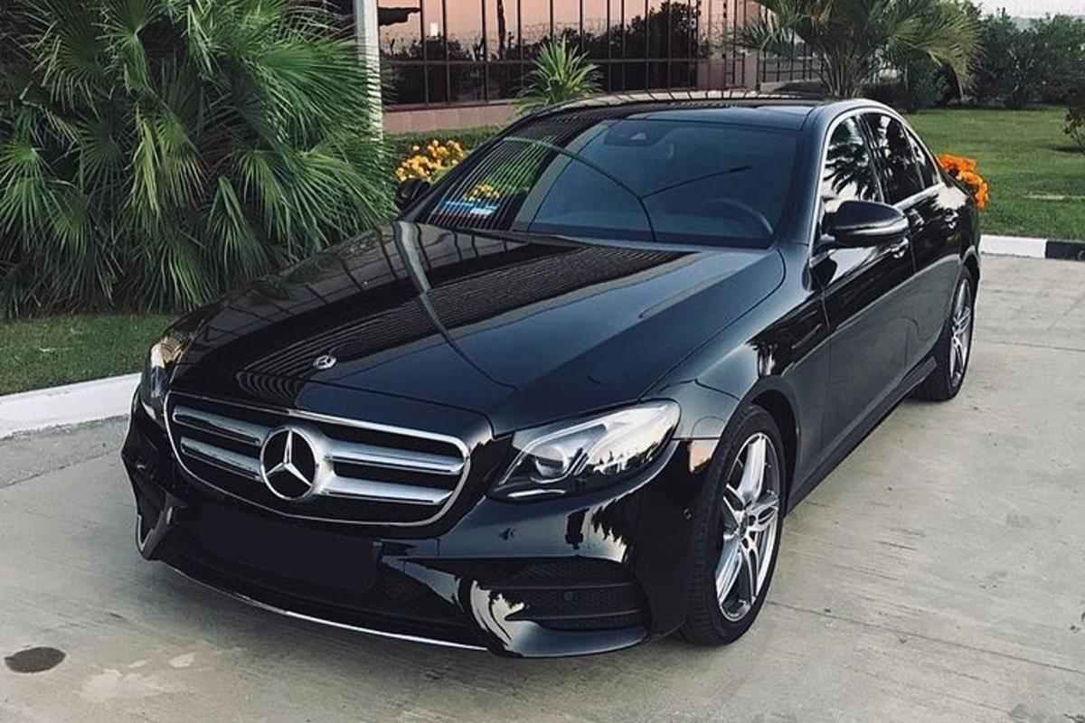 un'auto Mercedes Benz nera parcheggiata in un vialetto