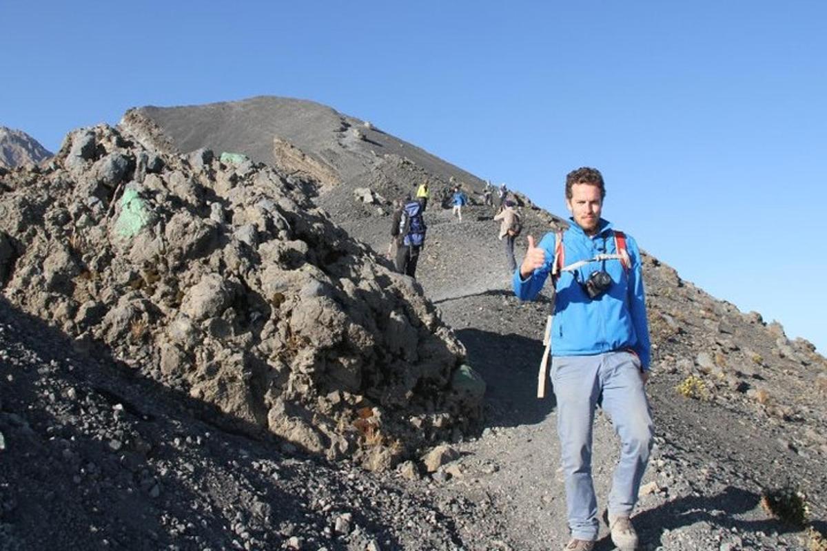 Maður stendur á fjalli með myndavél
